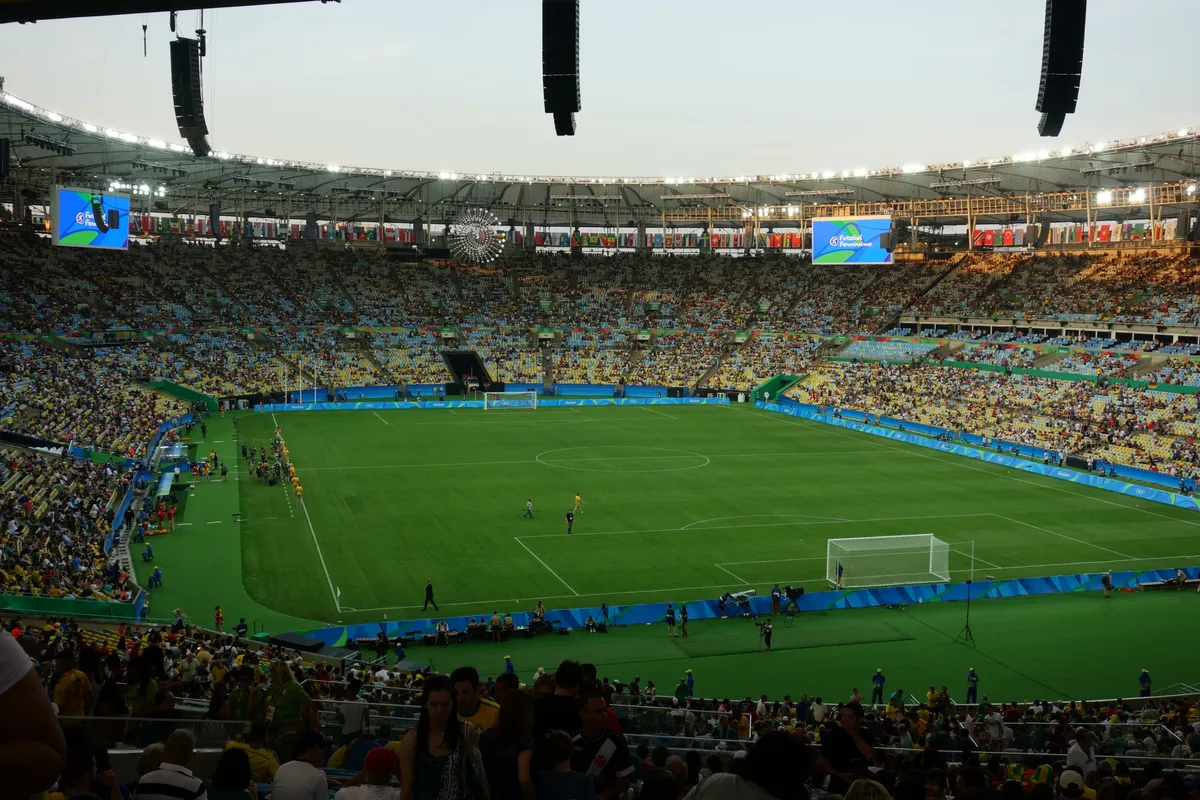Inside the Maracanã stadium at dusk, with full stands under the roof lights and the pitch ready for the women's Olympic final