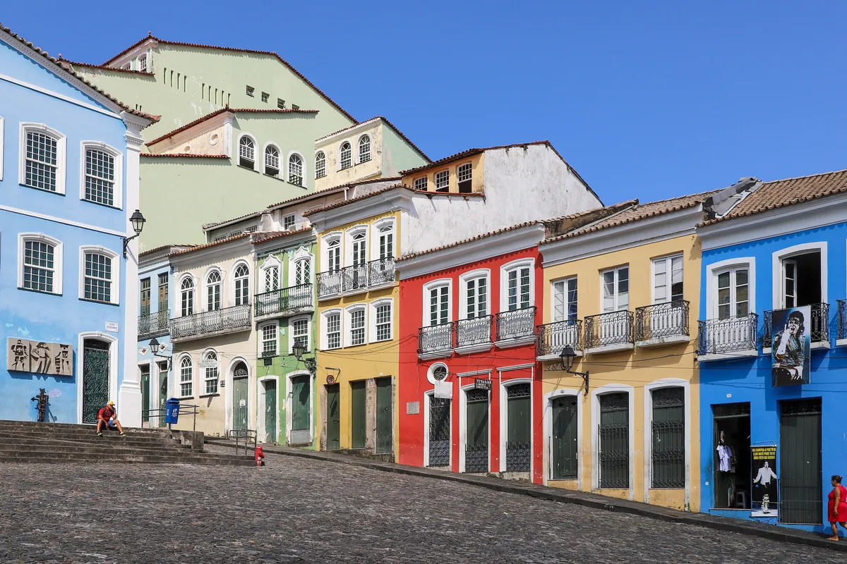 Colorful colonial houses in blue, red, yellow and green along a cobblestone street at the Largo do Pelourinho in Salvador, Bahia